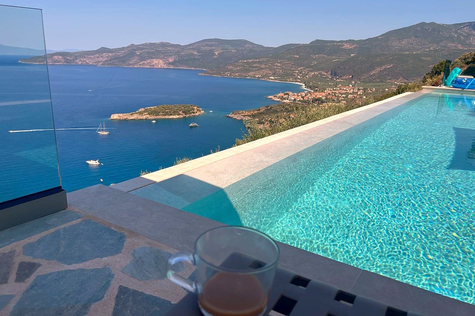 The infinity pool looking out over Kalamitsi bay, with the headland and an islet offshore.