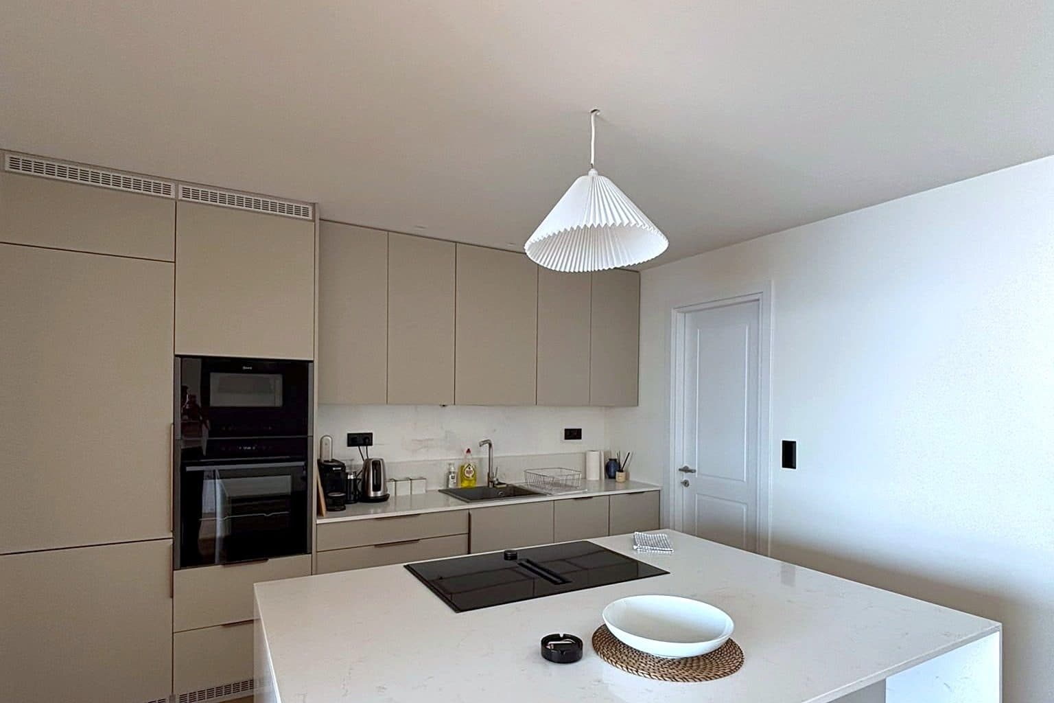 The kitchen, with a run of counter and cupboards and a window to the terrace.